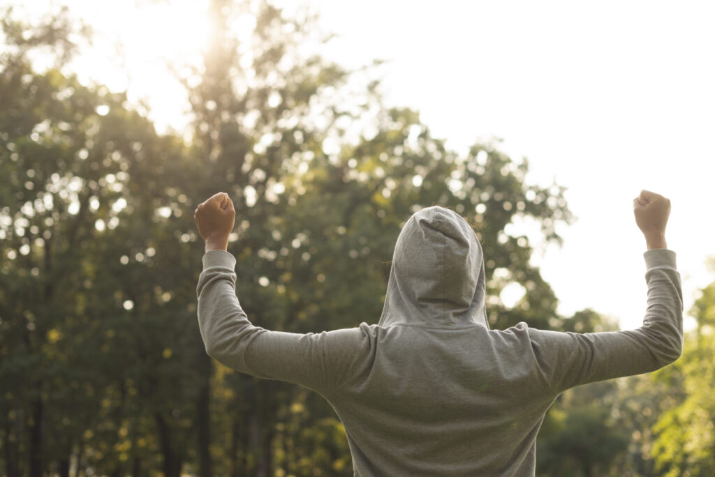 a person with hoodie being happy outside