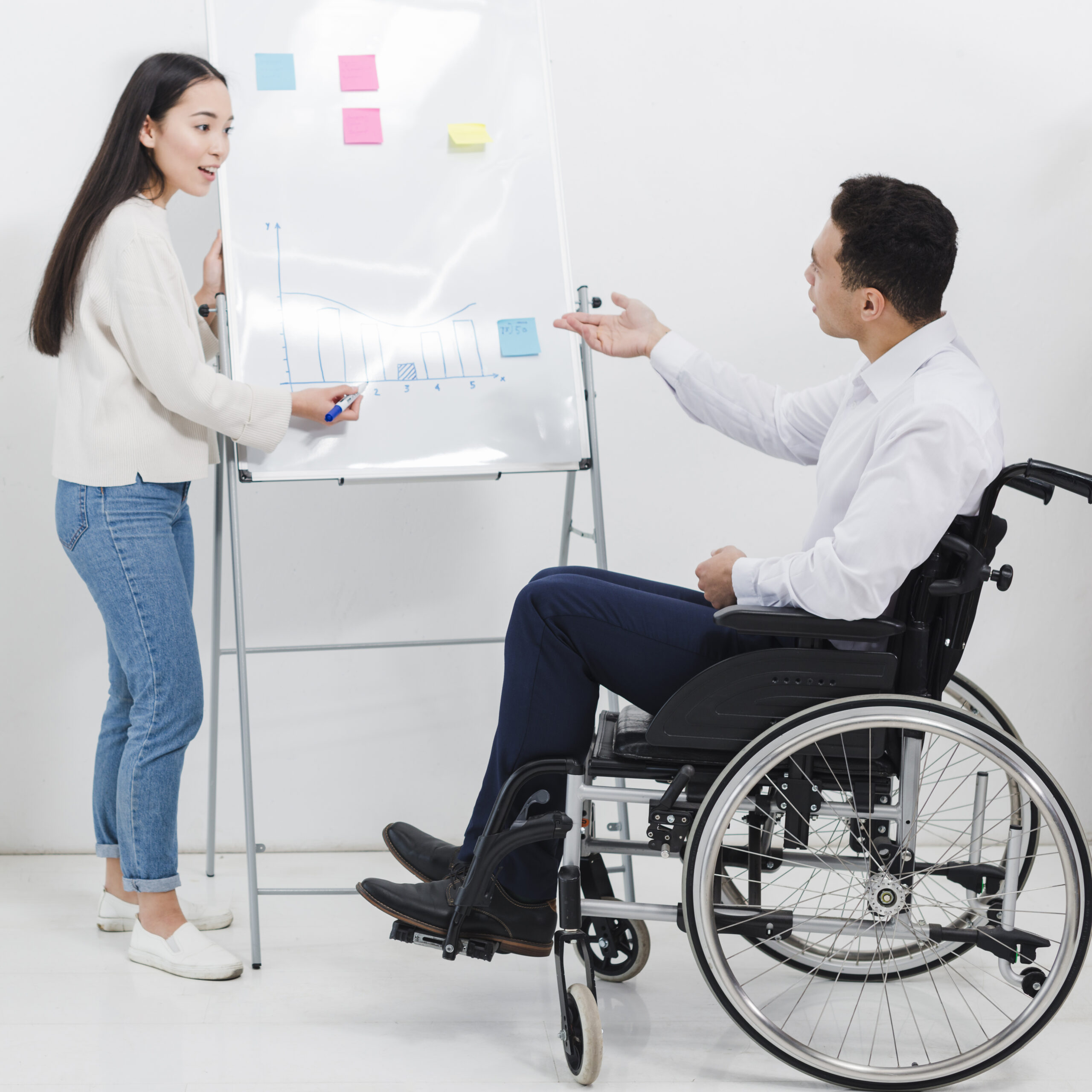 businessman-sitting-wheelchair-asking-something-young-woman-drawing-graph-whiteboard