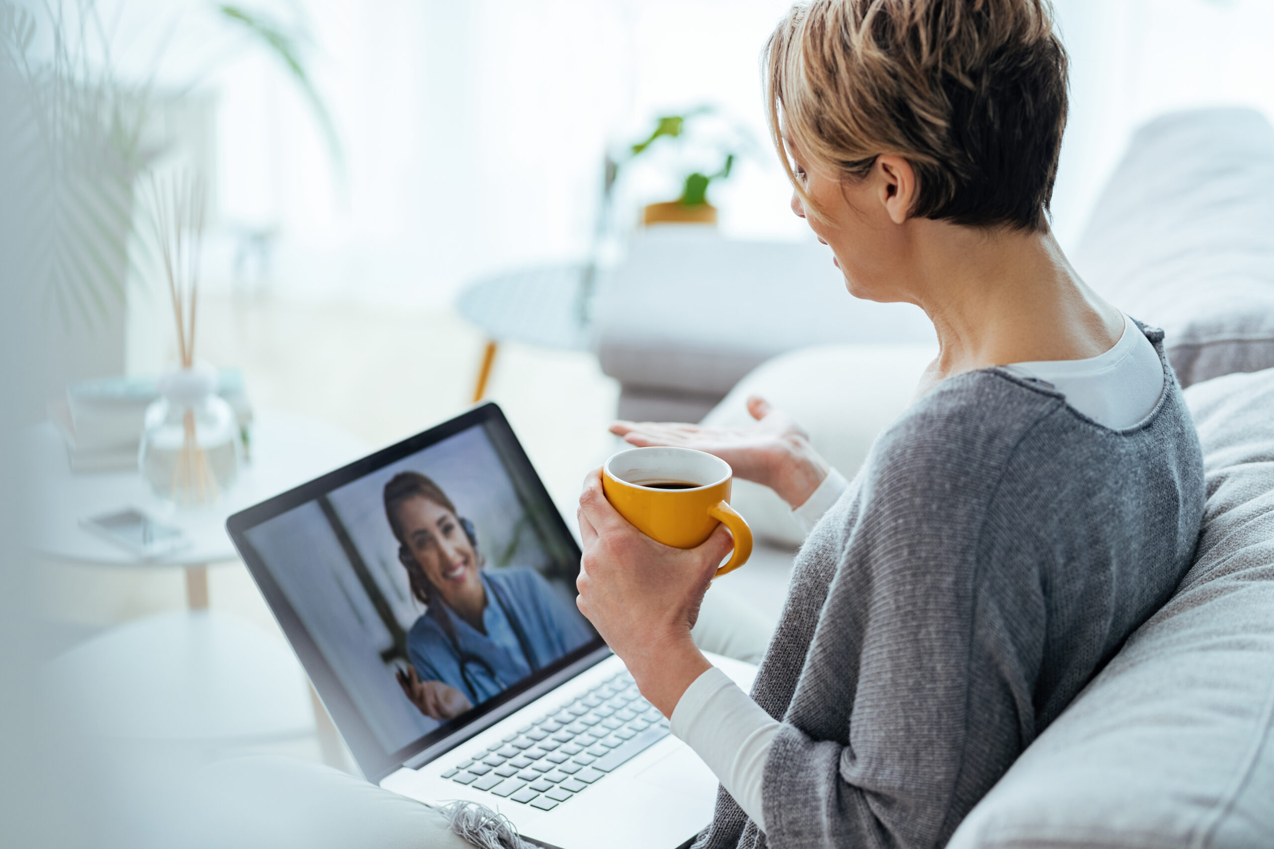 Woman using laptop and having video call with her doctor